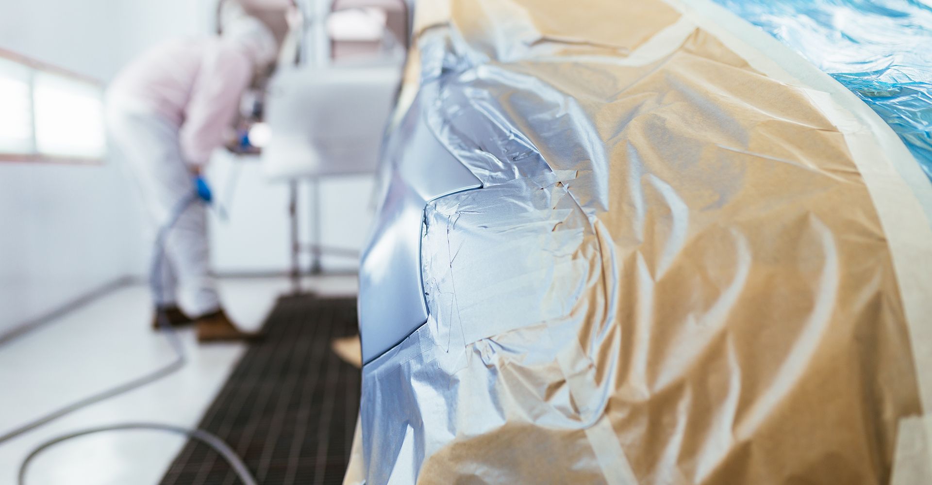 Lackiervorgang mit Auto im Vordergrund